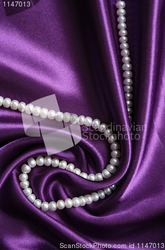 Image of White pearls on a lilac silk 