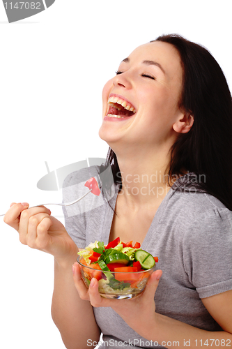 Image of Young attractive woman eats vegetable salad