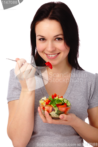 Image of Young attractive woman eats vegetable salad