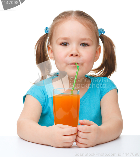 Image of Little girl drinks orange juice