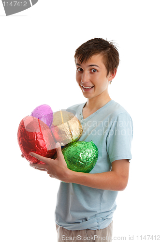 Image of Excited boy holding foil wrapped chocolate easter eggs