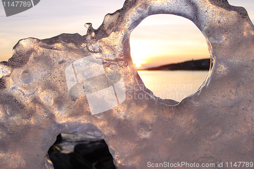 Image of Sunset through ice's holes in Finland