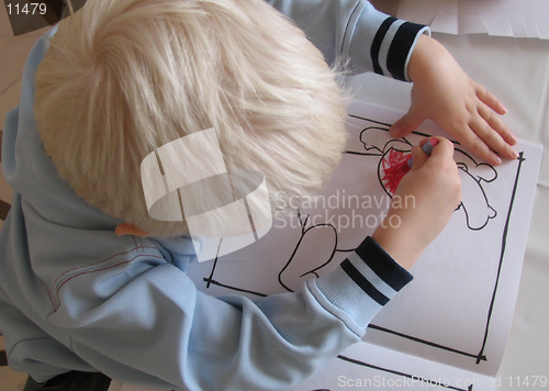 Image of Three year old boy with his colouring book seen from above.