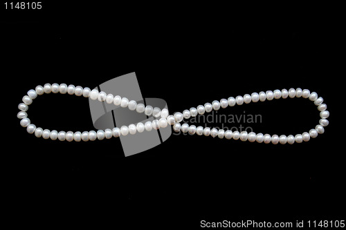 Image of White pearls on the black silk as background 