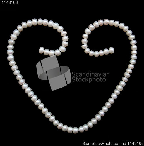 Image of White pearls on the black silk as background 