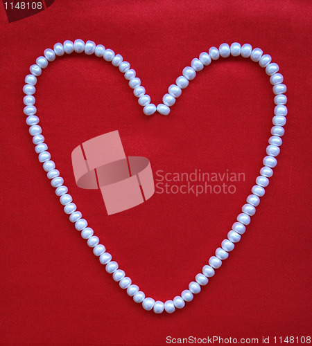 Image of Heart from white pearls on a red silk for St Valentine's day 