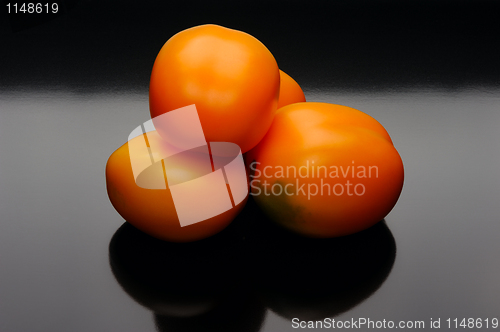 Image of Orange tomatoes on a black backgrouns