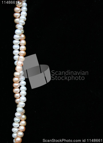 Image of White and pink pearls on the black background