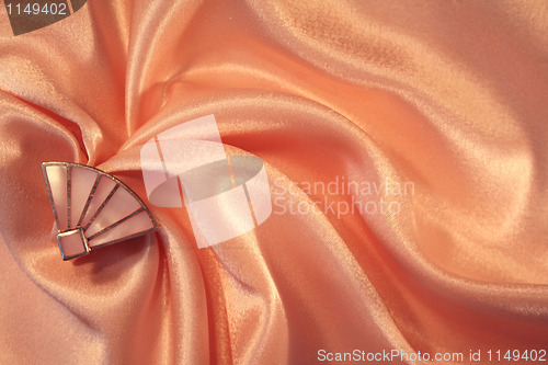 Image of Silver fan from nacre on the elegant pink silk 