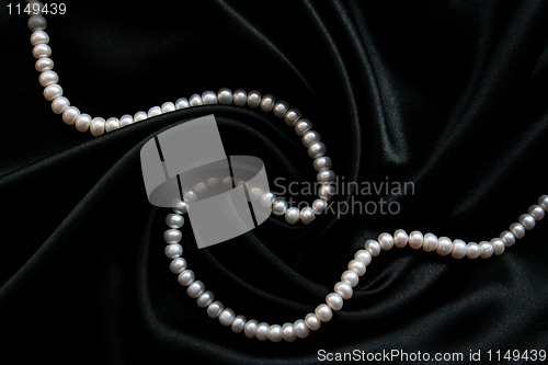 Image of White pearls on the black silk 