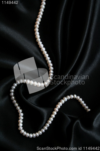 Image of White pearls on the black silk 