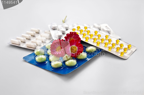 Image of Tablets and capsules with daisies