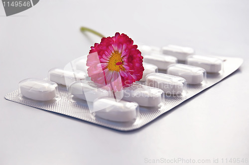 Image of White round pill with daisy