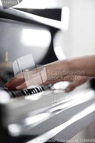 Image of Close-up of girl's hands on piano