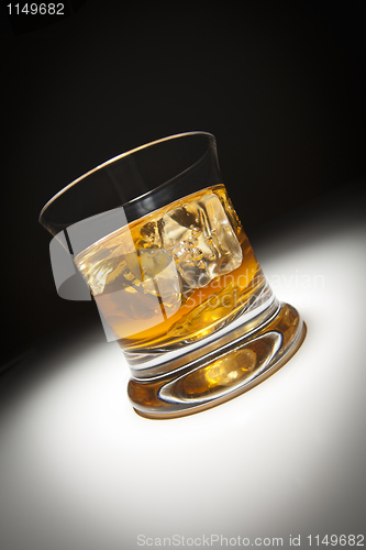 Image of Glass of Whiskey and Ice Under Spot Light.