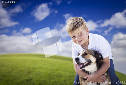 Image of Handsome Young Boy Playing with His Dog in the Grass