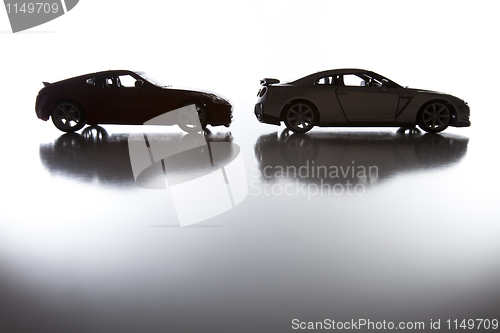 Image of Silhouette of Sports Cars on Reflective Surface 