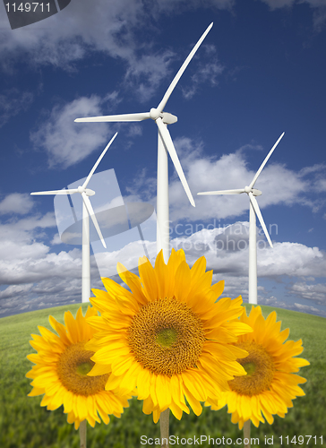 Image of Wind Turbines Against Dramatic Sky with Bright Sunflowers