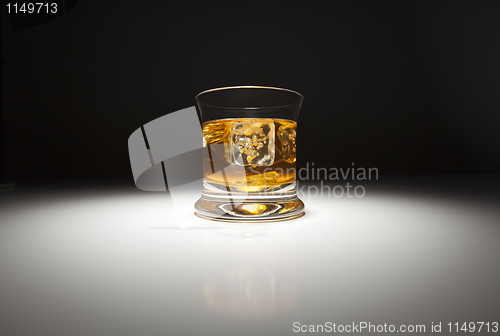 Image of Glass of Whiskey and Ice Under Spot Light.