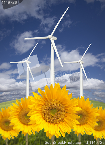 Image of Wind Turbines Against Dramatic Sky with Bright Sunflowers