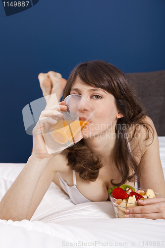 Image of Drinking orange juice on bed