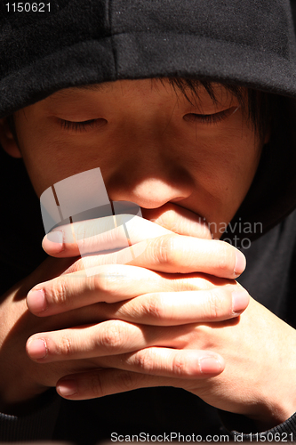 Image of Closeup portrait of a young man praying to god