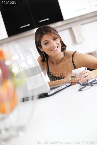 Image of Modern woman reading e-mails at her breakfast
