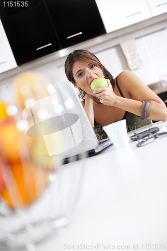 Image of Modern woman reading e-mails at her breakfast