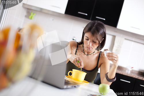 Image of Modern woman reading e-mails at her breakfast