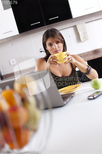 Image of Modern woman reading e-mails at her breakfast