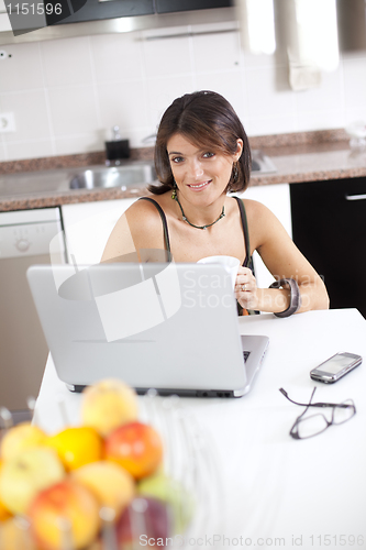 Image of Modern woman reading e-mails at her breakfast