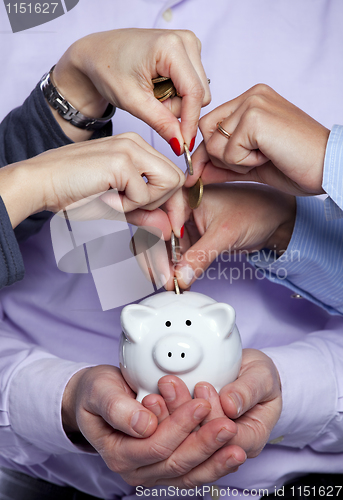 Image of Hands inserting money in the piggybank