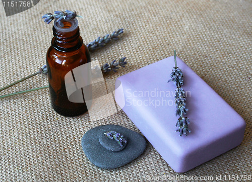 Image of Lavender flowers, bottle of essential oil and soap in a spa comp