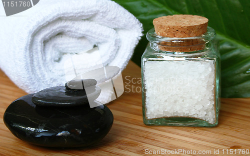 Image of White bath towel, bottle of sea salt and stones in spa compositi
