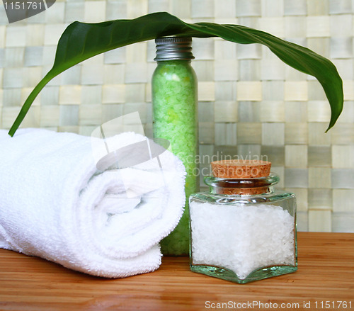 Image of White bath towel, bottle of sea salt in spa composition