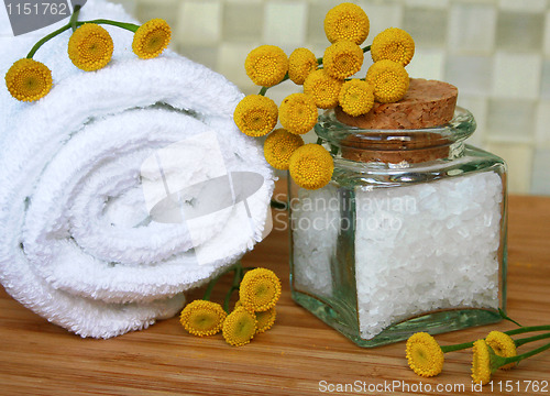 Image of White bath towel, bottle of sea salt in spa composition