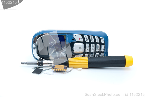 Image of Broken mobile phone, screwdriver and microchips