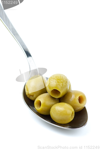 Image of Five marinated pitted green olives in the metal spoon