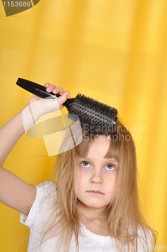 Image of girl treying to brush her hair