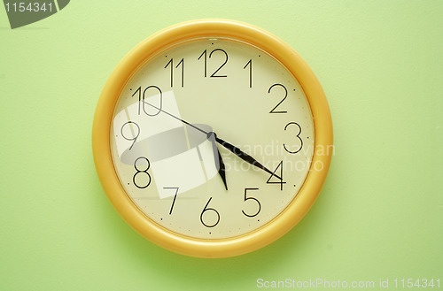 Image of Yellow wall clock on the green