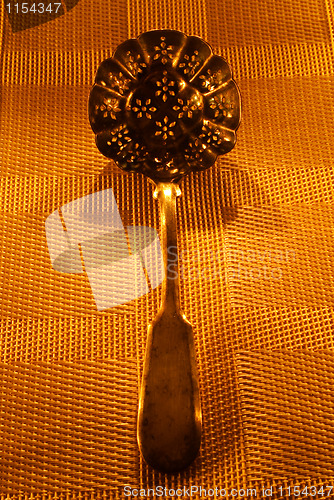 Image of vintage silver serving spoon on candle lights