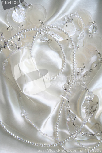 Image of White pearls and nacreous beeds on white silk as wedding backgro