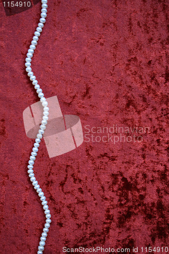 Image of Necklace of white pearls on a terracotta velvet 