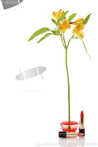 Image of perfume bottle, yellow flower and two red lipstick