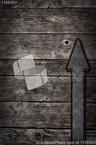 Image of rusty arrow on wooden background