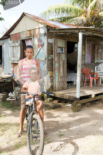 Image of Nicaragua mother daughter bicycle poverty house Corn Island 