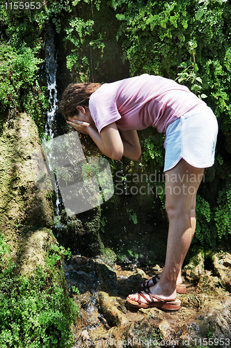 Image of A girl washes in the stream.