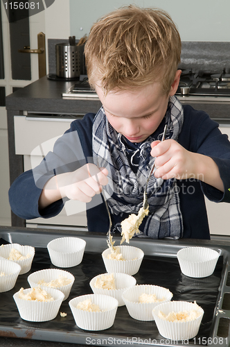 Image of Kid Filling Cakecups With Dough