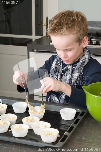 Image of Kid Filling Cakecups With Dough