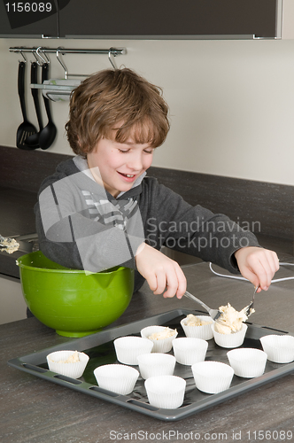 Image of Kid Filling Cakecups With Dough